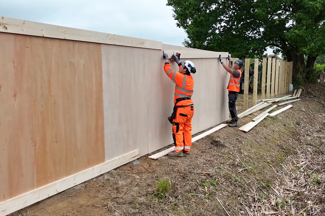 dug in timber hoarding being installed