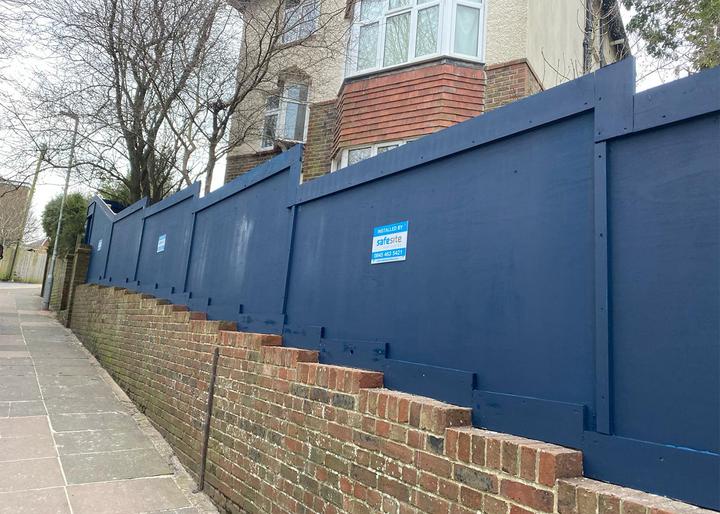 Dug-in timber hoarding residential property finished