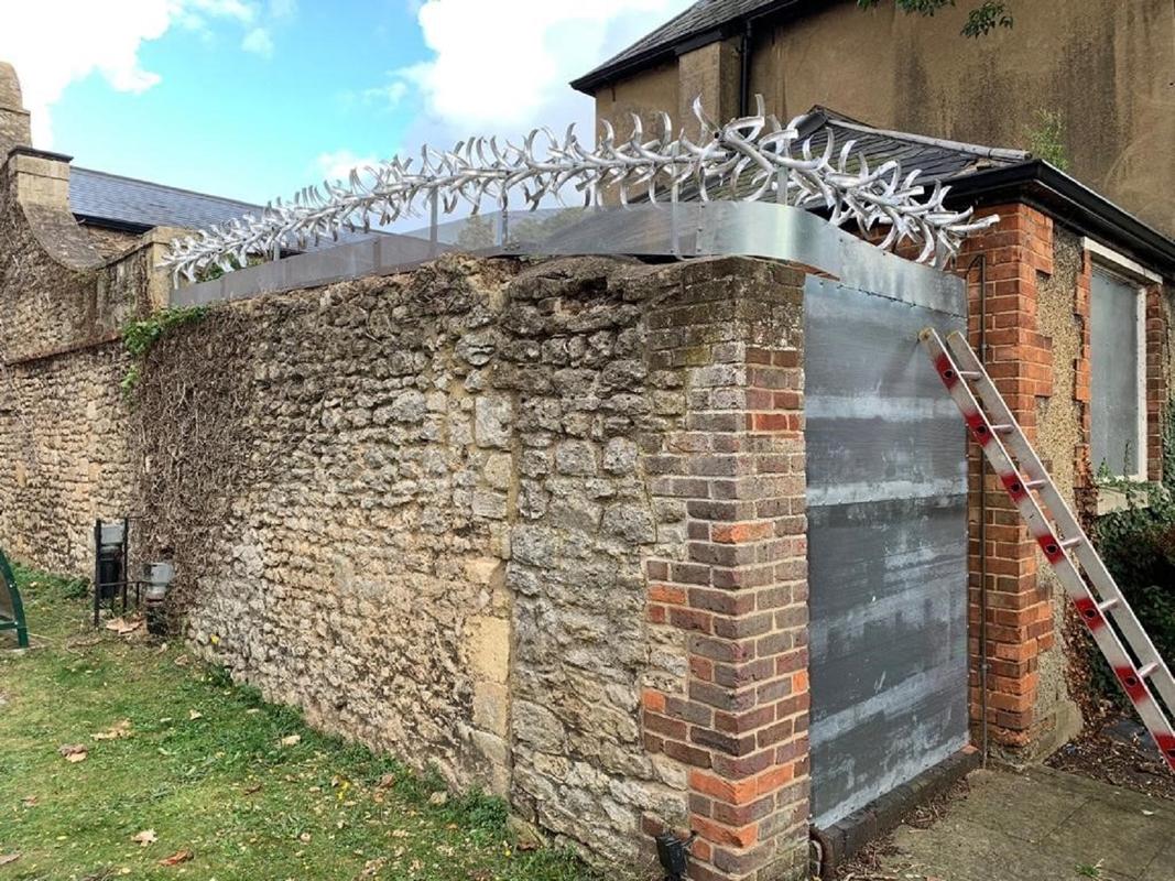 anti-climb spikes over a stone wall