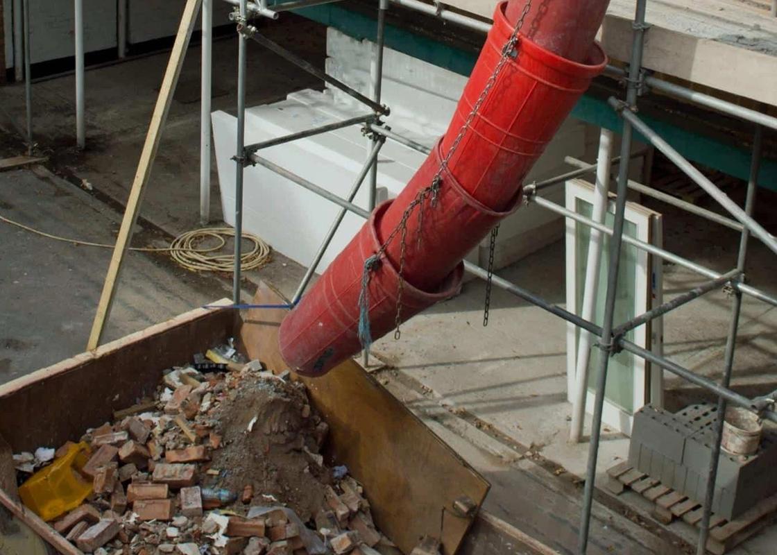 20 inch rubbish chutes attached showing debris landing in skip