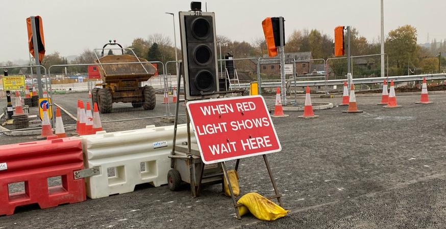 Roadworks sign propped against water filled barrier from SafeSite