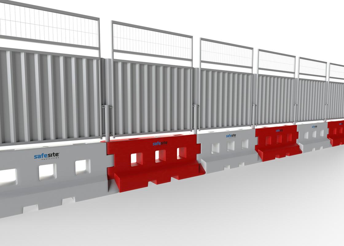 Line of GB2 water filled barriers with hoarding with a mesh extension from the reverse side