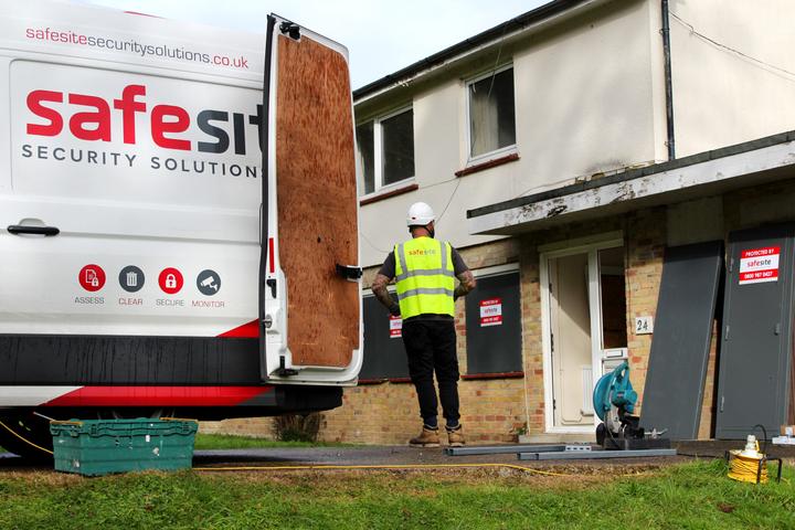 safesite worker in the process of installing sitex security screens at vacant property