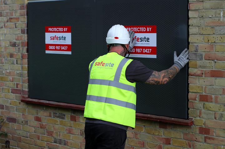 sitex steel security screens being installed on vacant property by worker