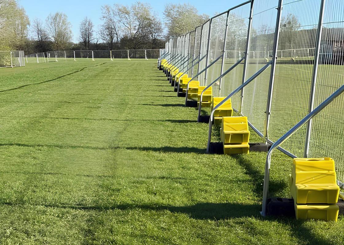 temporary fencing on field with hi vis concrete ballast block
