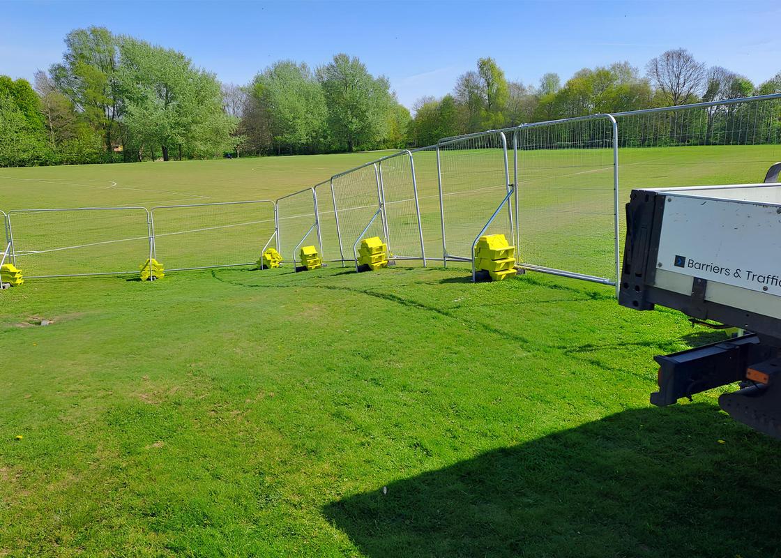 temporary fencing on field with hi vis concrete ballast block