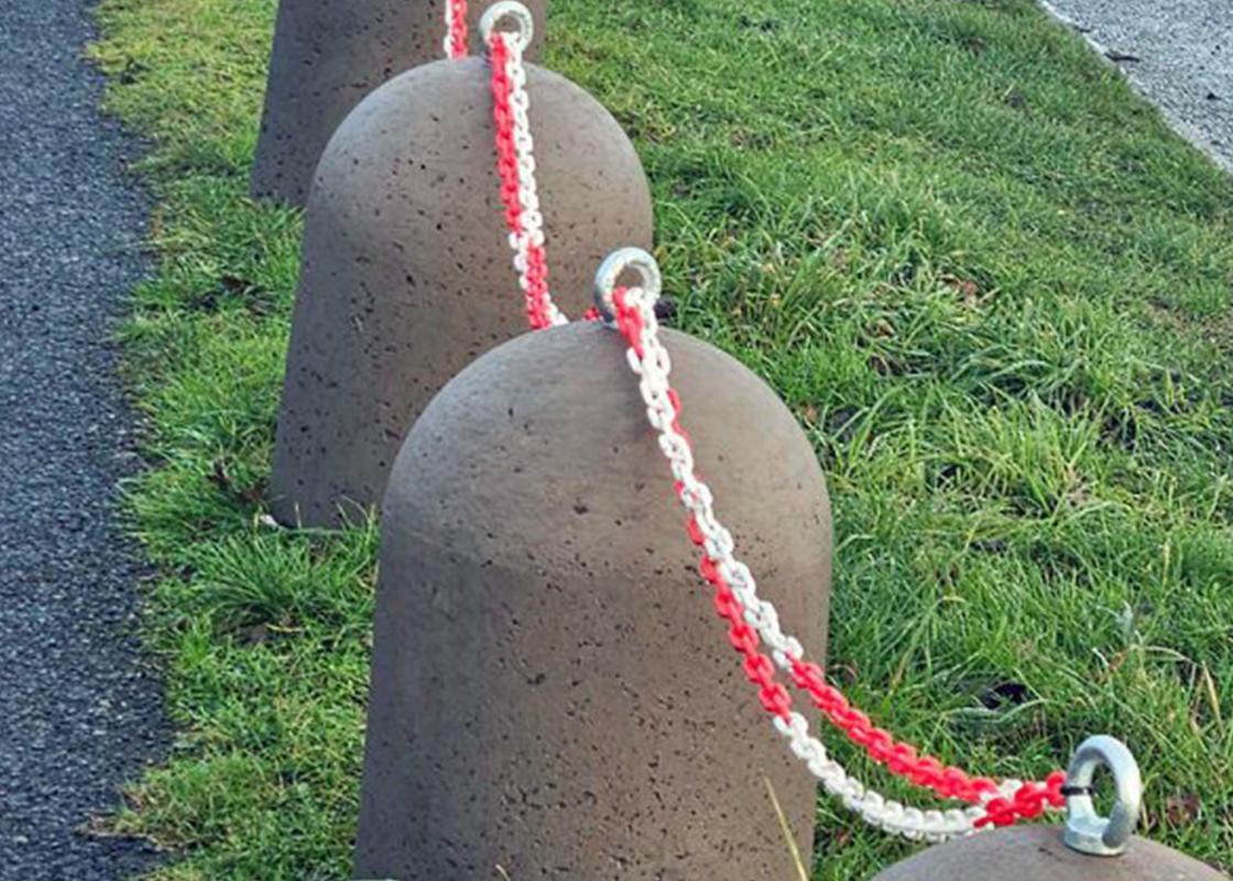close up of concrete stub bollard in situ with barrier chains connecting bollards
